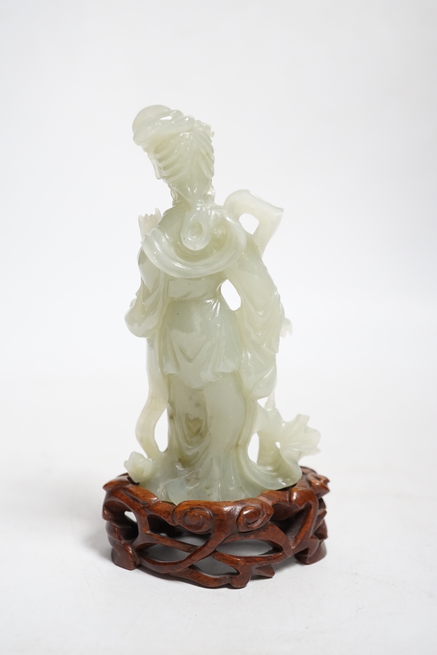 A Chinese celadon jade figure of a lady, on wood stand, 13cms high.